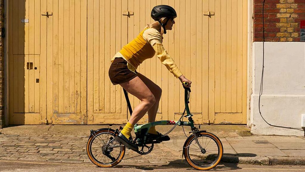 Brompton Tour de France C Line trifold bike with black frame, yellow accents, and race-day photography print