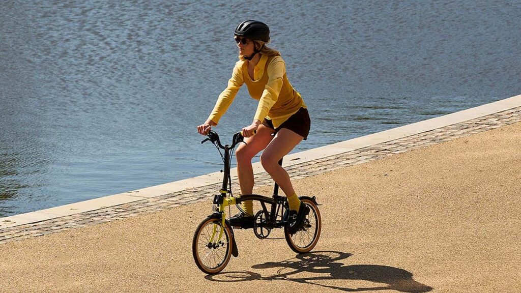 Brompton Tour de France C Line trifold bike with black frame, yellow accents, and race-day photography print