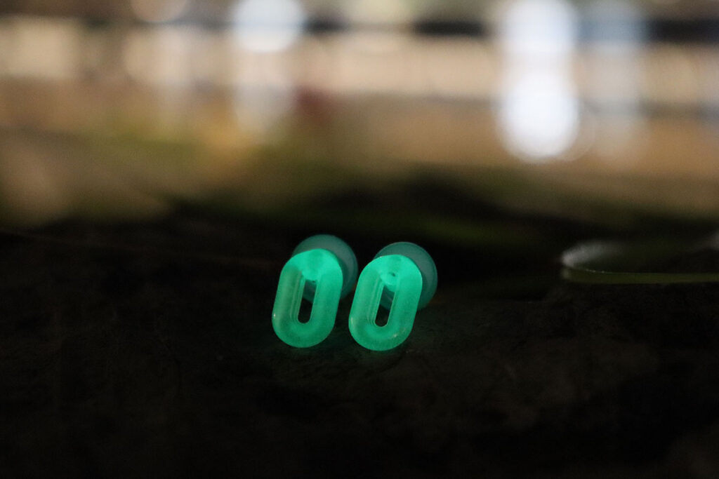 Saccater Luna glow-in-the-dark modular concert earplug set illuminated in a dark environment