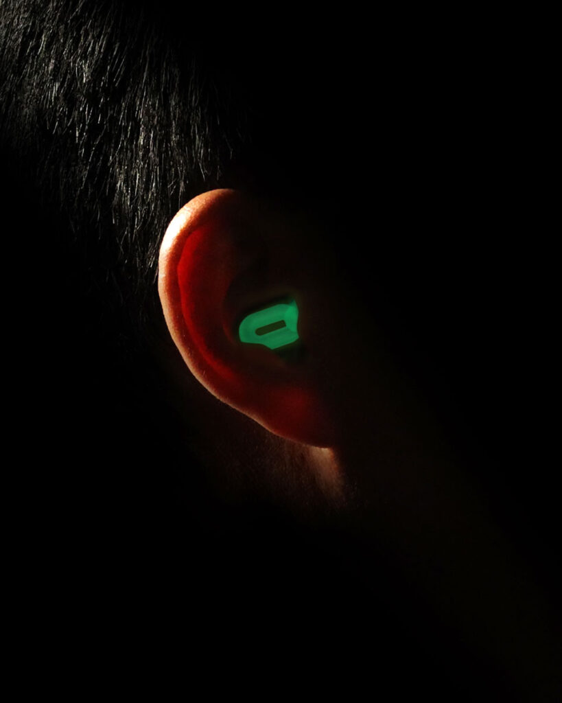 Saccater Luna glow-in-the-dark modular concert earplug set illuminated in a dark environment
