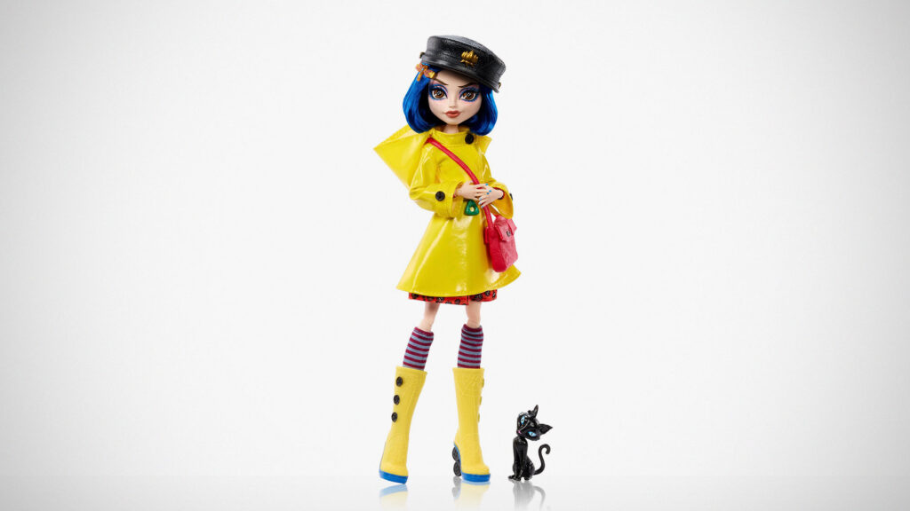 Monster High Skullector Coraline doll wearing yellow raincoat with rag doll and cat accessories