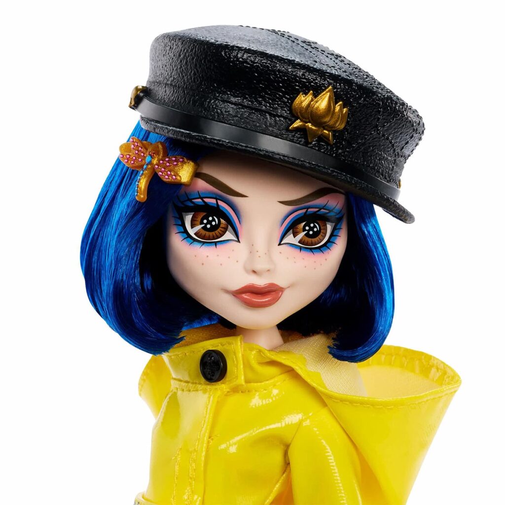 Monster High Skullector Coraline doll wearing yellow raincoat with rag doll and cat accessories