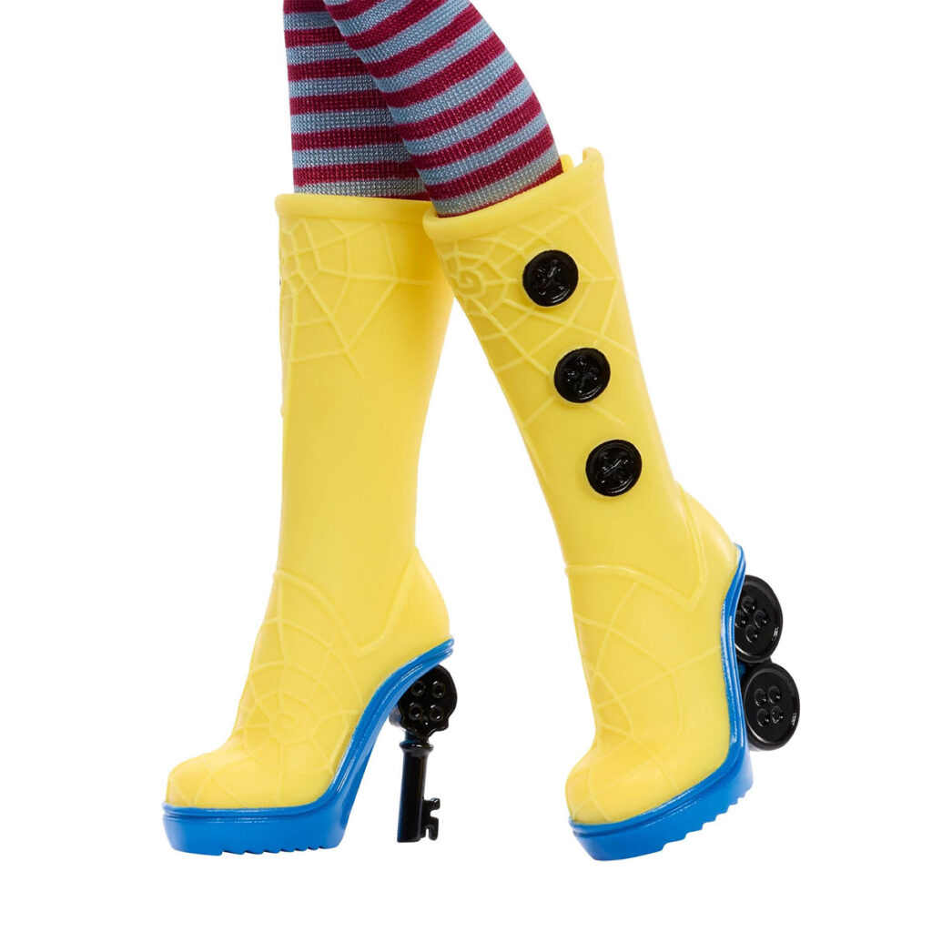 Monster High Skullector Coraline doll wearing yellow raincoat with rag doll and cat accessories